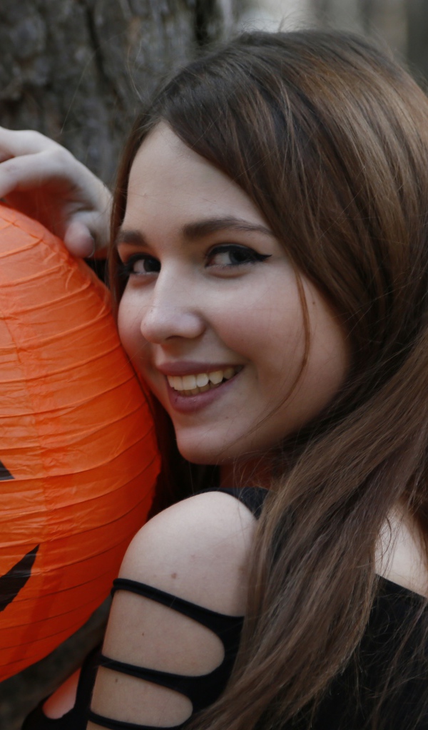 Улыбающаяся девушка с декором на праздник Хэллоуин