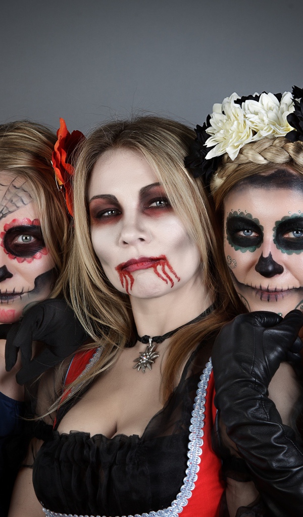 Три девушки с масками и в костюмах на Хэллоуин 