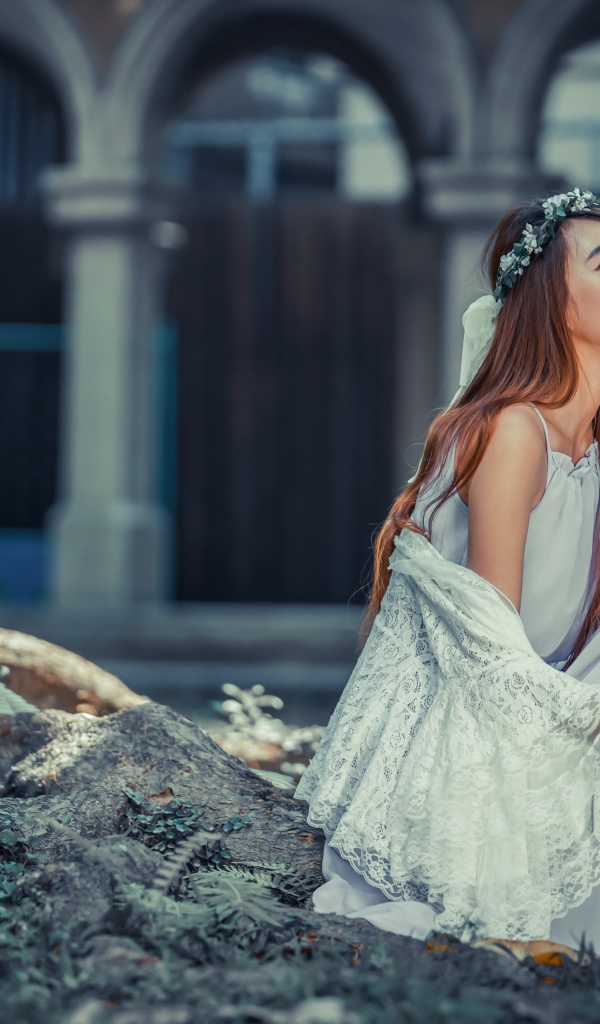 Мечтательная девушка азиатка в белом платье