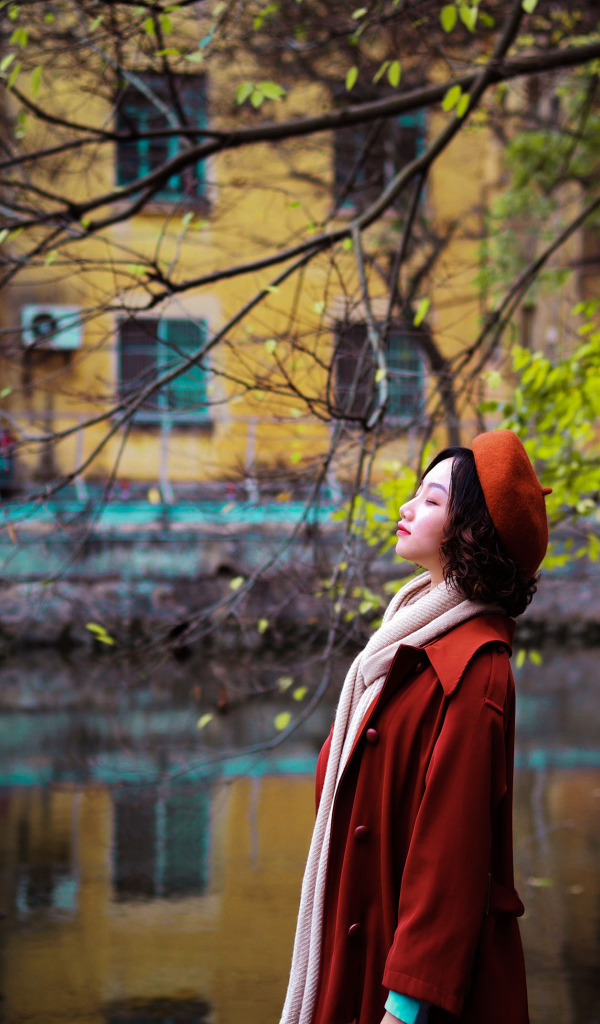 Девушка азиатка в красном пальто у воды