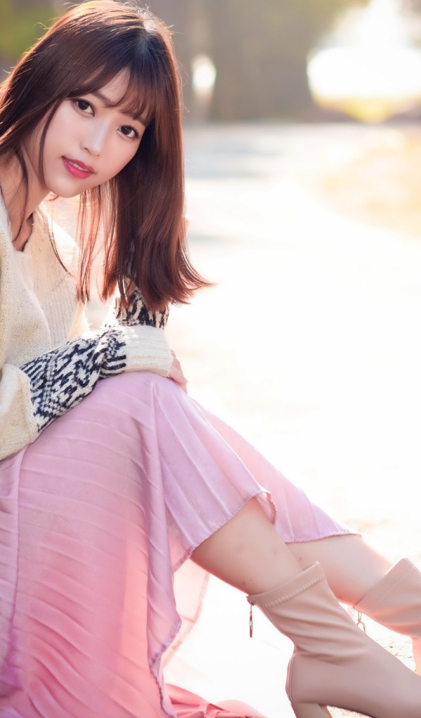 Девушка азиатка сидит на земле 