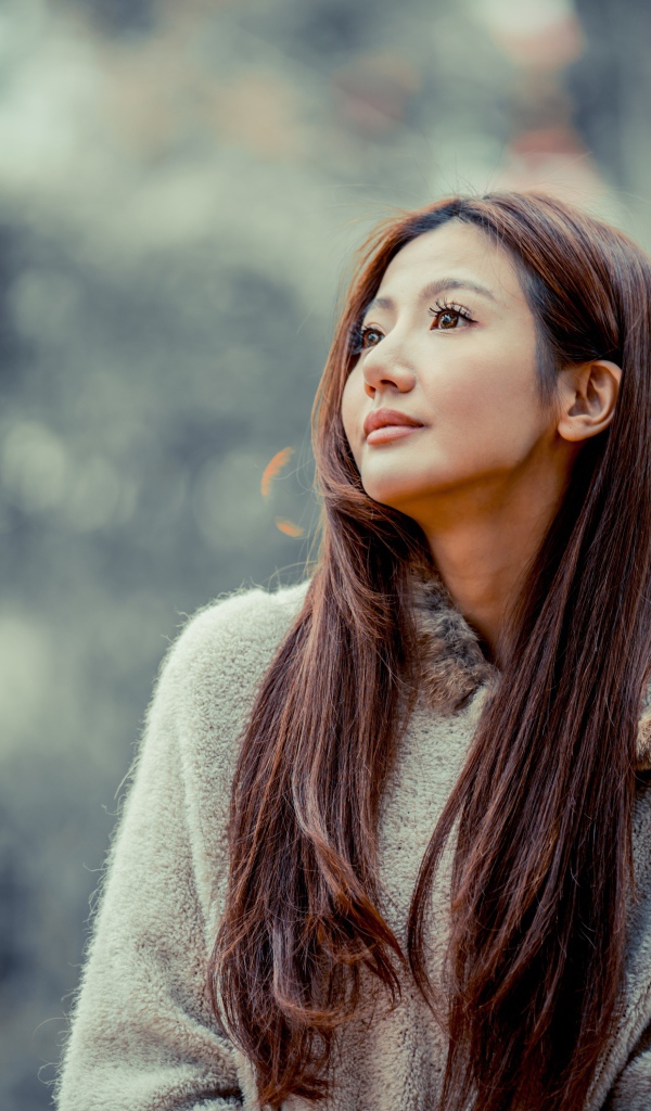 Длинноволосая девушка азиатка смотрит в сторону