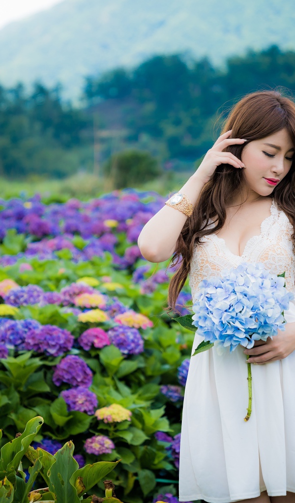 Красивая девушка азиатка в белом платье с цветами гортензии 