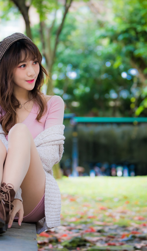 Красивая девушка азиатка сидит на земле 