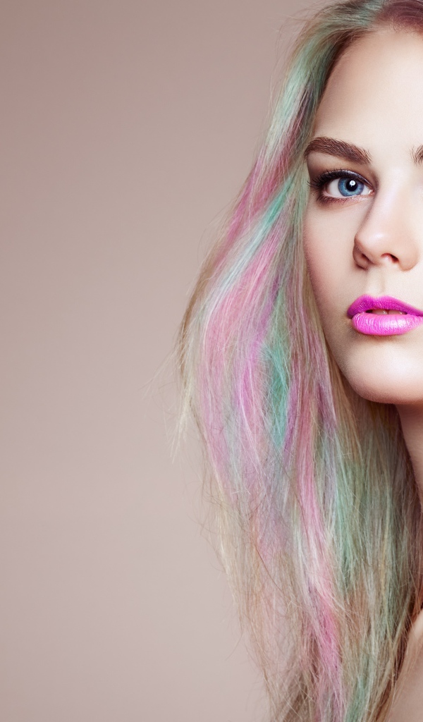 Красивая голубоглазая девушка с разноцветными волосами на сером фоне