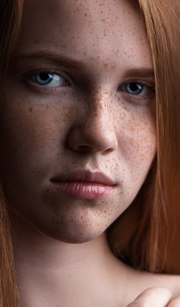Красивая голубоглазая рыжеволосая девушка с веснушками