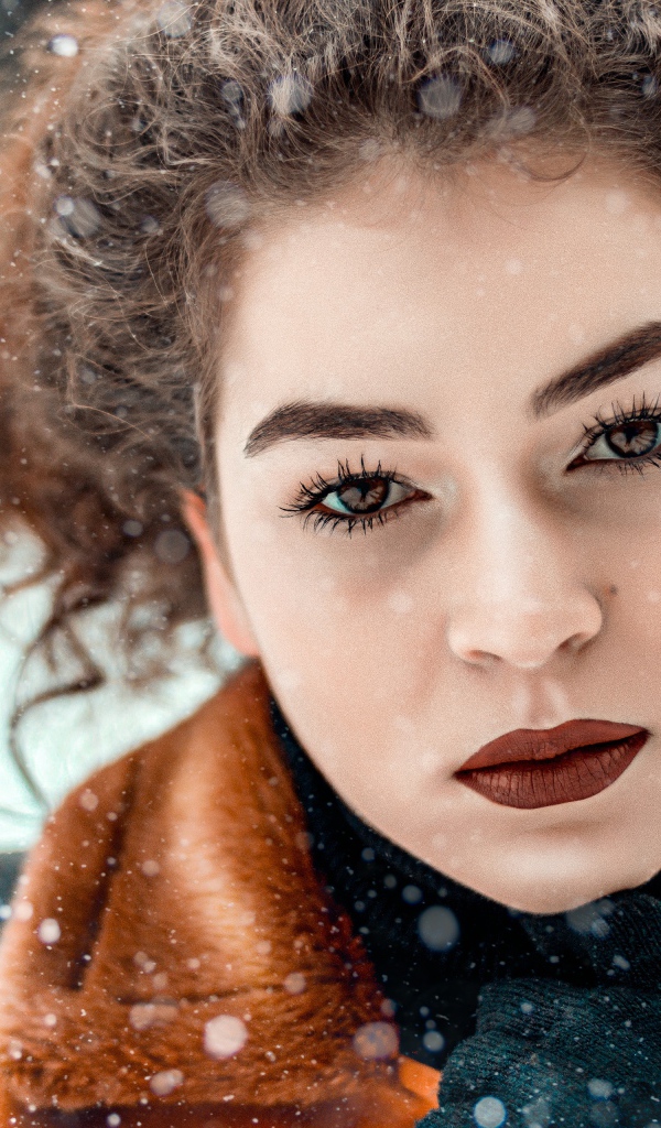 Красивая кареглазая девушка стоит на улице зимой