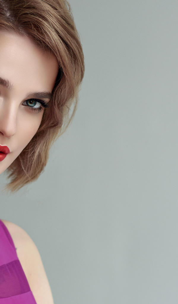 Красивая девушка шатенка с короткой стрижкой на сером фоне