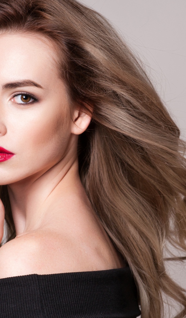 Красивая шатенка с красными губами на сером фоне