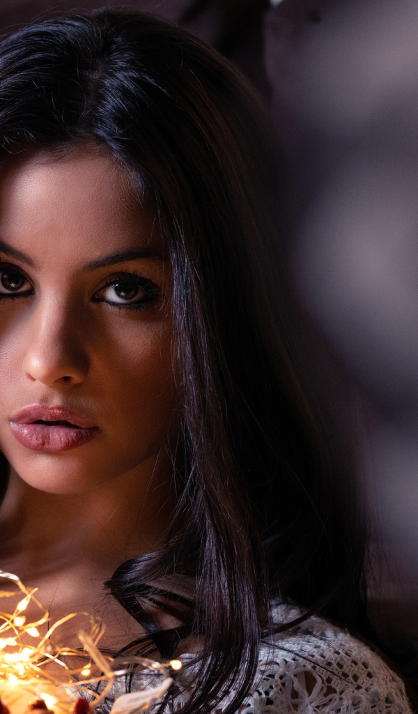 Красивая брюнетка с гирляндой в руках