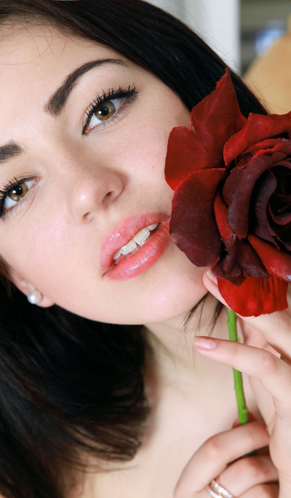 Красивая брюнетка с красной розой в руке