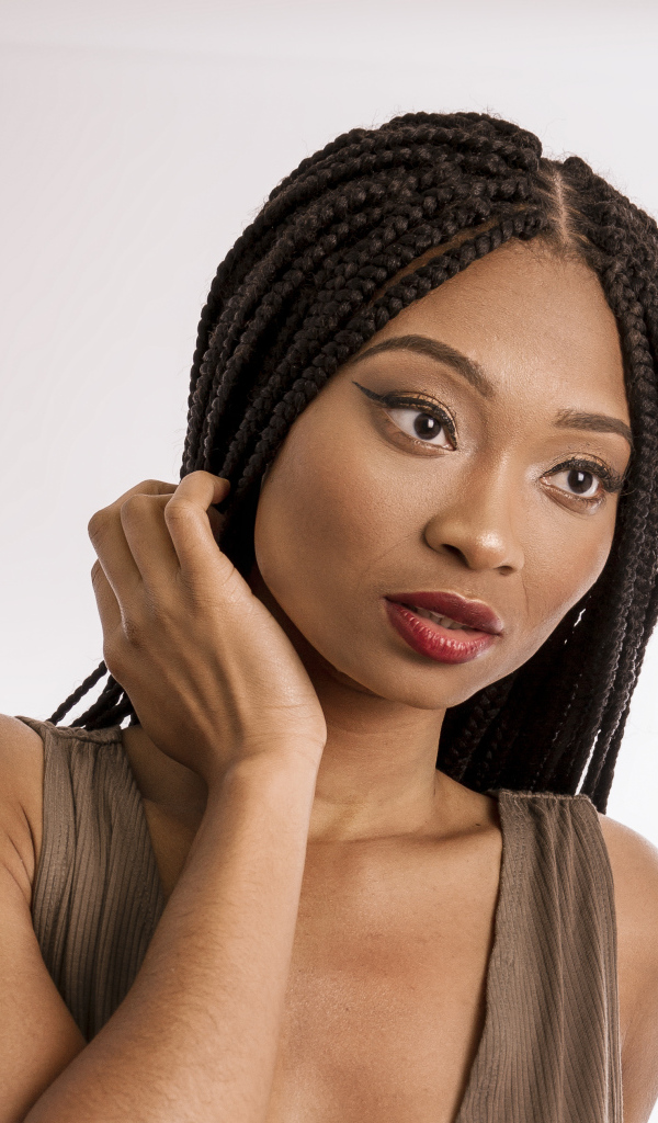 Красивая темнокожая девушка с косичками на голове