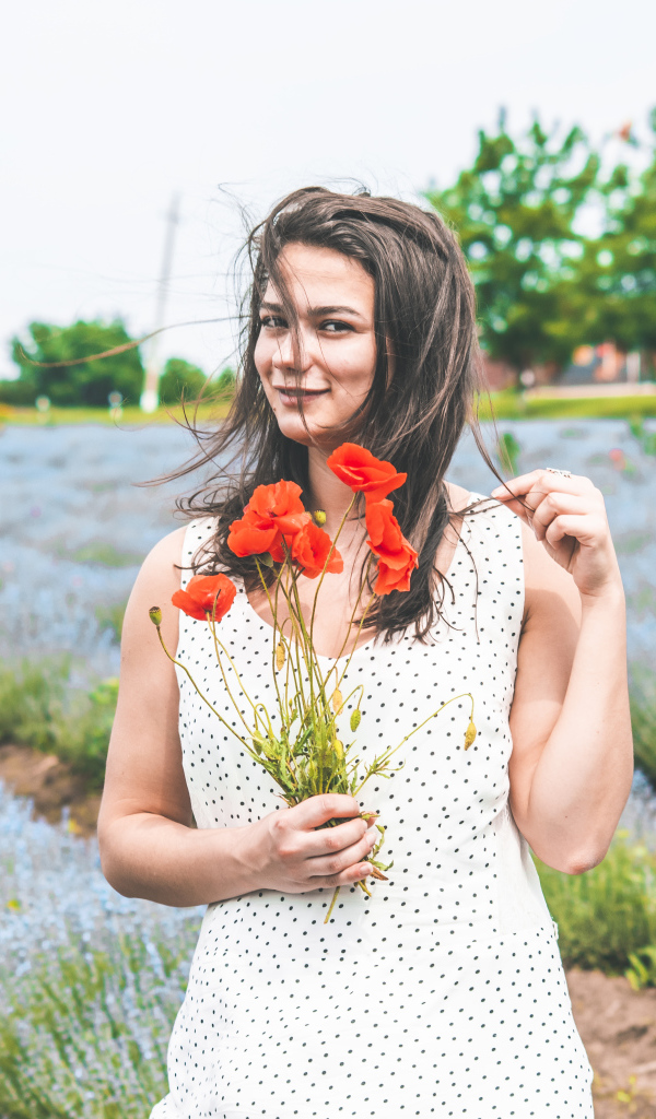 Красивая девушка в платье с букетом маков