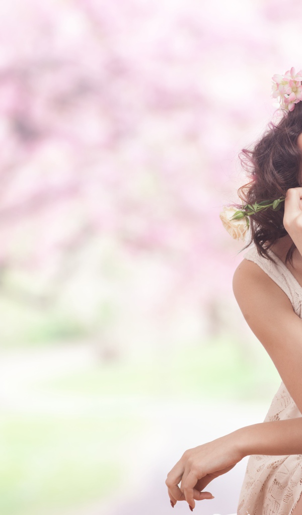 Красивая девушка в розовом платье с венком на голове