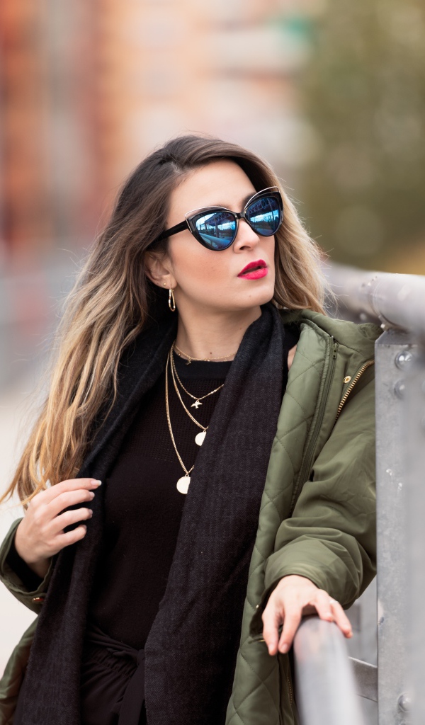 Красивая девушка в солнечных очках на мосту