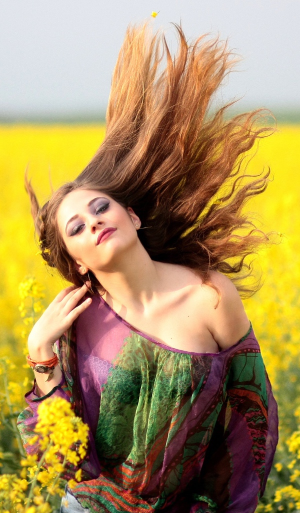 Красивая девушка на поле с желтыми цветами