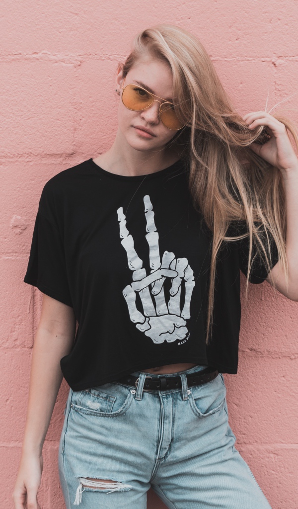 Красивая девушка стоит у розовой стены 