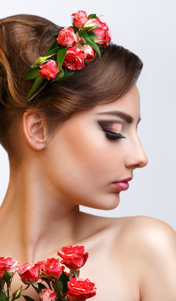 Красивая девушка с прической и венком из роз в волосах 