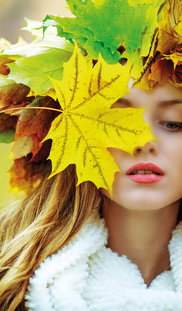 Красивая девушка с венком из листьев осенью