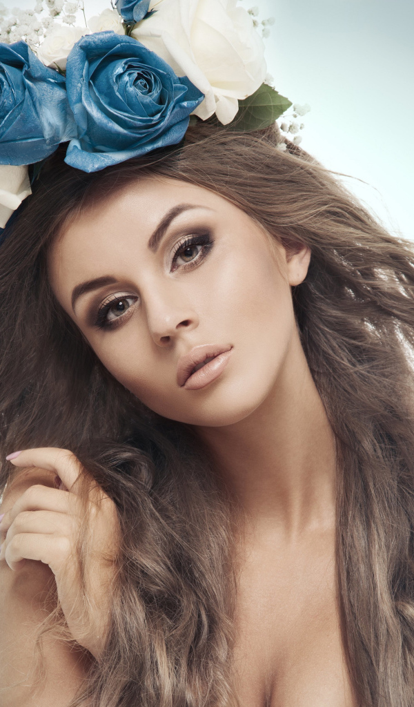 Красивая девушка с венком на голове на сером фоне