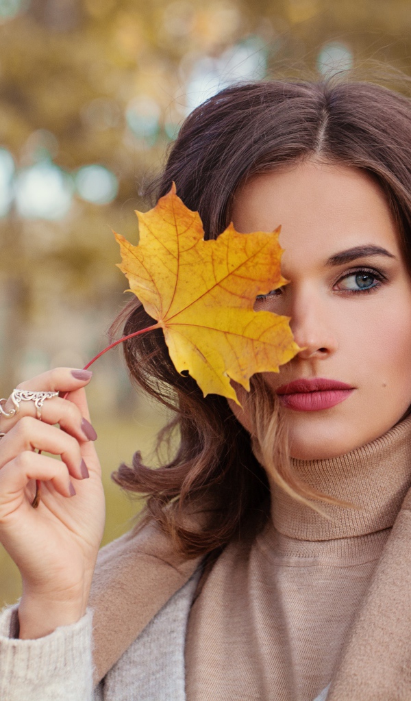 Красивая девушка с осенним листом в руке