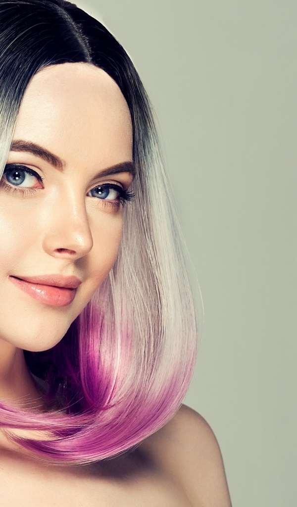 Красивая девушка с крашеными волосами на сером фоне