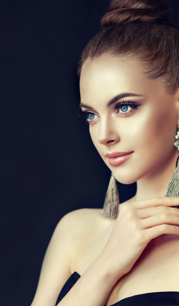 Красивая девушка с серьгами на черном фоне