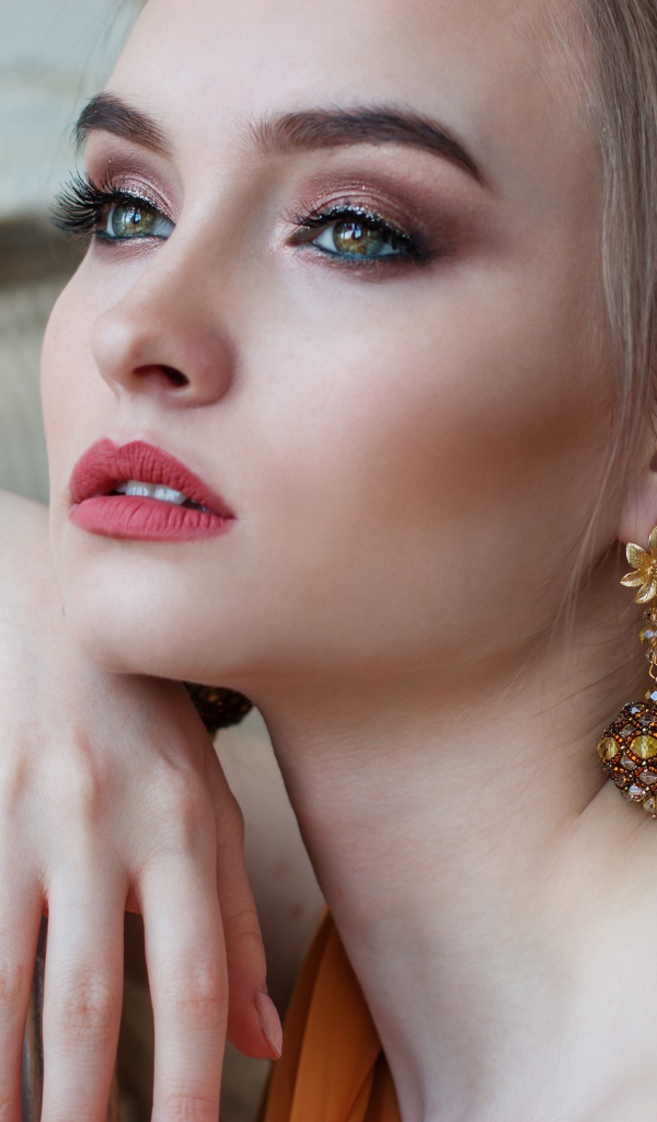 Красивая девушка с длинными ресницами с красивыми серьгами в ушах