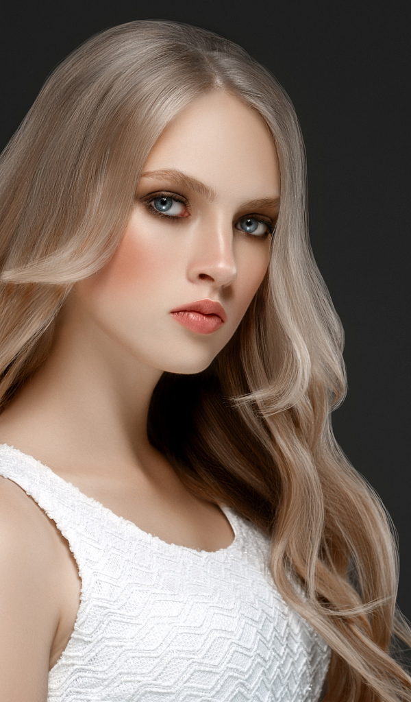 Красивая девушка с длинными  белыми волосами на сером фоне