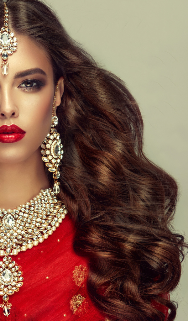 Красивая длинноволосая шатенка в индийском сари с украшениями