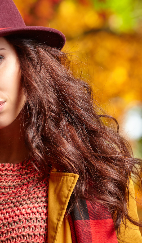 Красивая длинноволосая девушка в шляпе осенью
