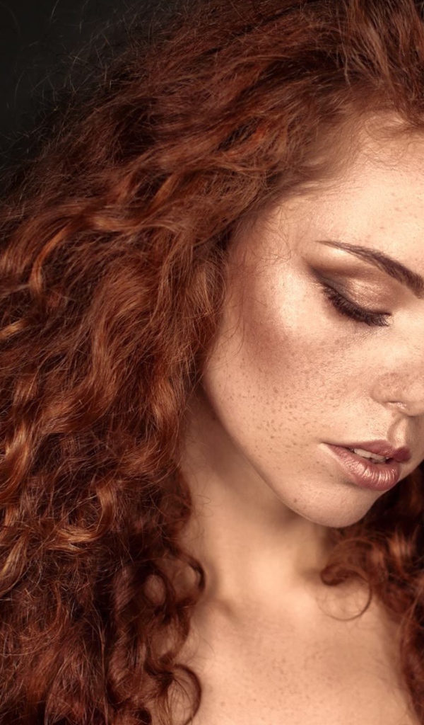 Красивая скромная рыжеволосая девушка с веснушками