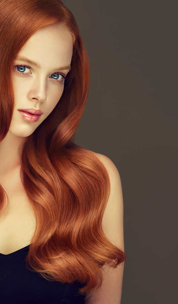 Красивая рыжеволосая голубоглазая девушка на сером фоне