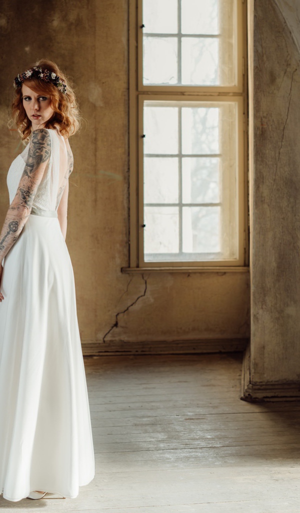 Красивая рыжеволосая девушка в белом платье с  татуировками на теле 