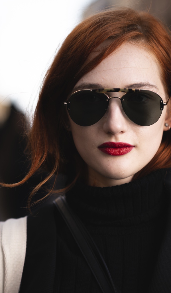 Красивая рыжеволосая девушка в темных очках