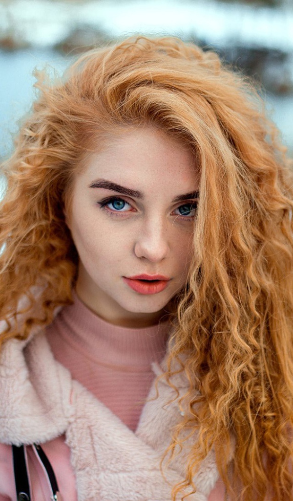Красивая рыжеволосая девушка с голубыми глазами зимой