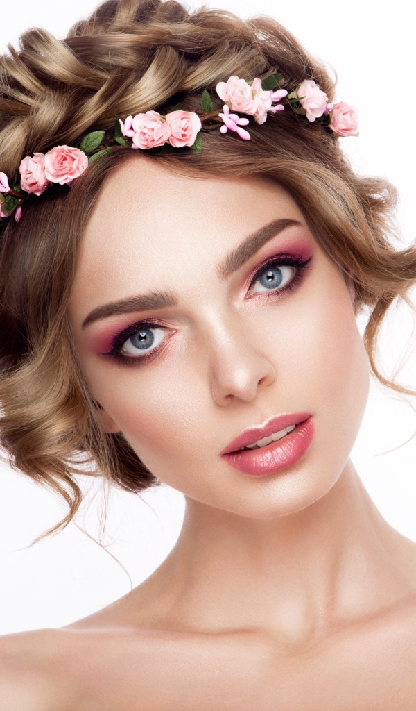 Красивая нежная голубоглазая девушка с венком на голове на белом фоне