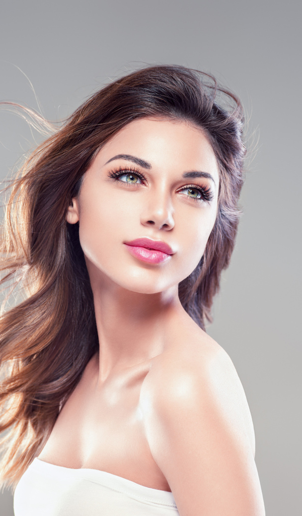 Красивая нежная девушка шатенка на сером фоне