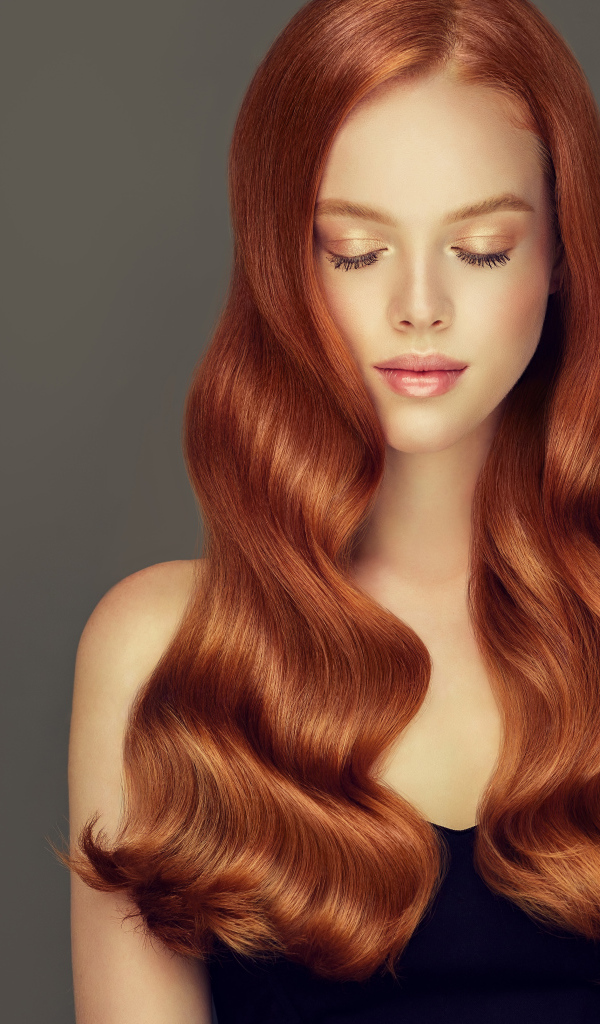 Красивая нежная рыжеволосая девушка на сером фоне