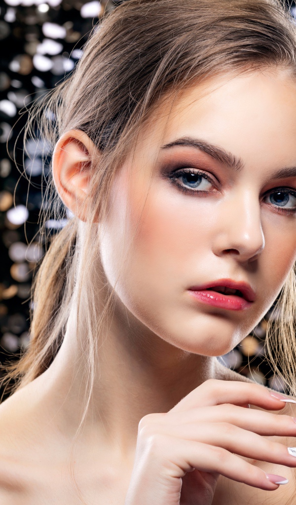 Красивая молодая голубоглазая девушка с маникюром