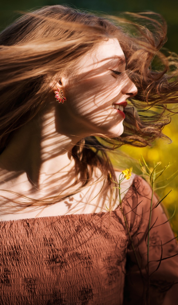 Красивая молодая девушка на поле с желтыми цветами