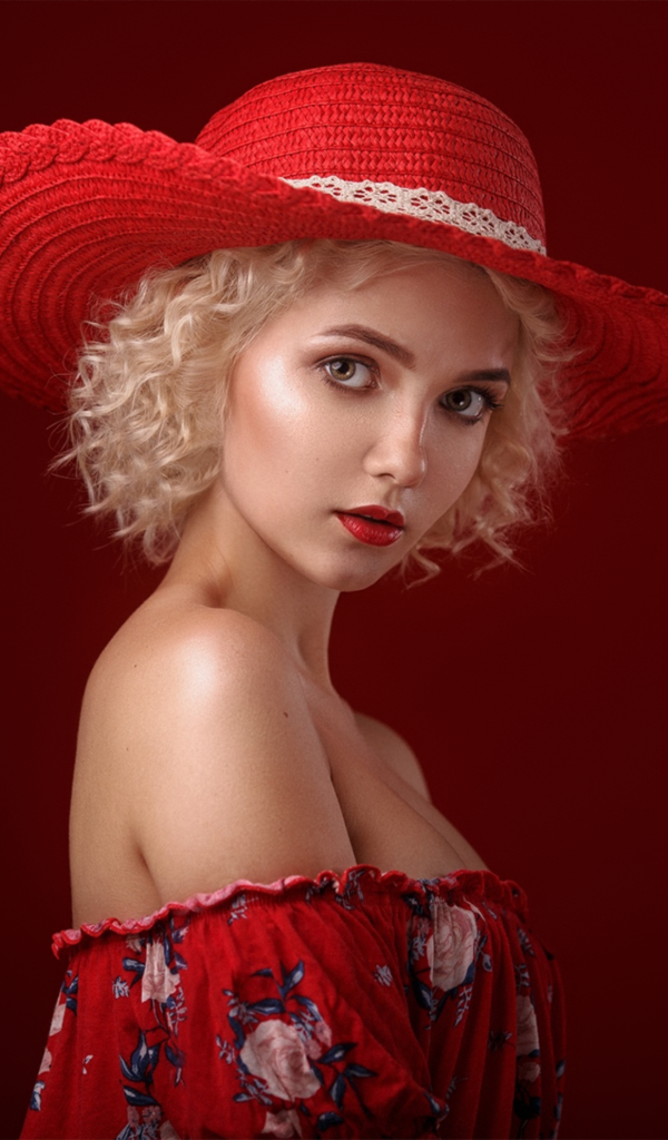 Блондинка в шляпе на красном фоне