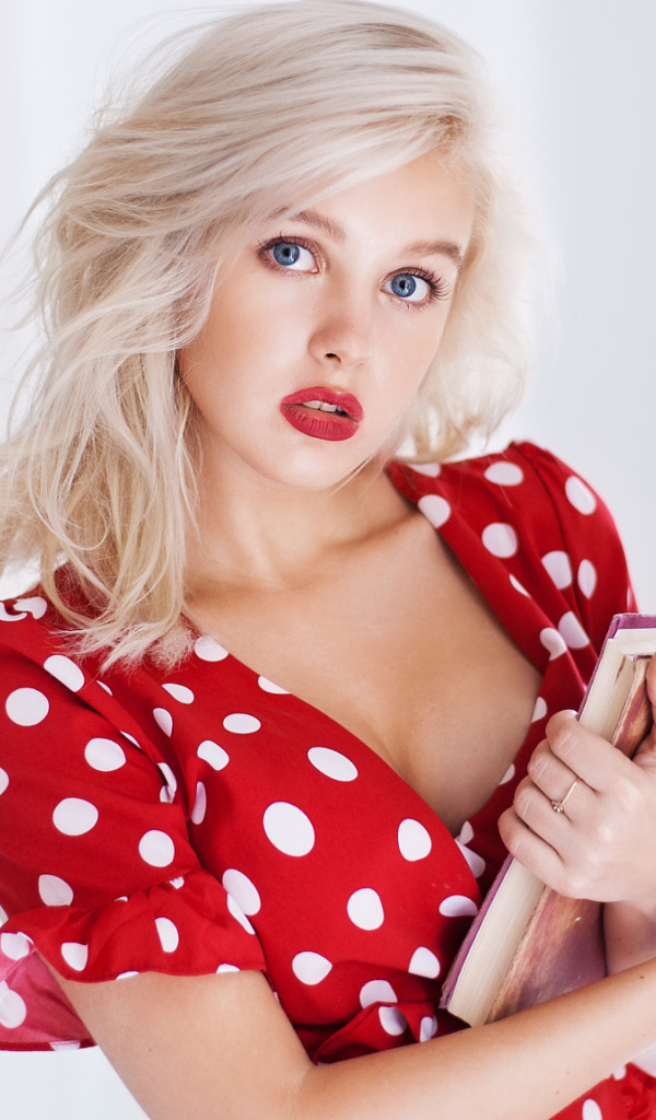 Голубоглазая блондинка в красном платье с книгой в руке 