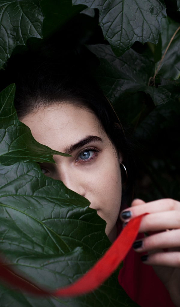 Голубоглазая девушка в больших зеленых листьях