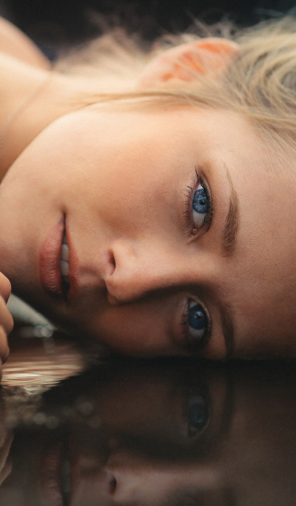 Голубоглазая девушка модель лежит на полу