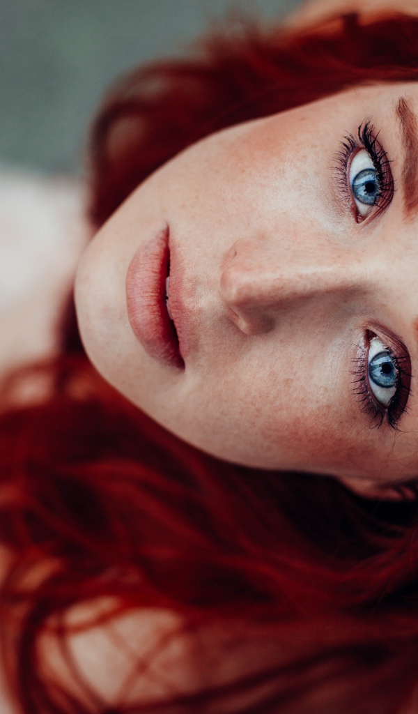 Голубоглазая рыжеволосая девушка с веснушками на лице