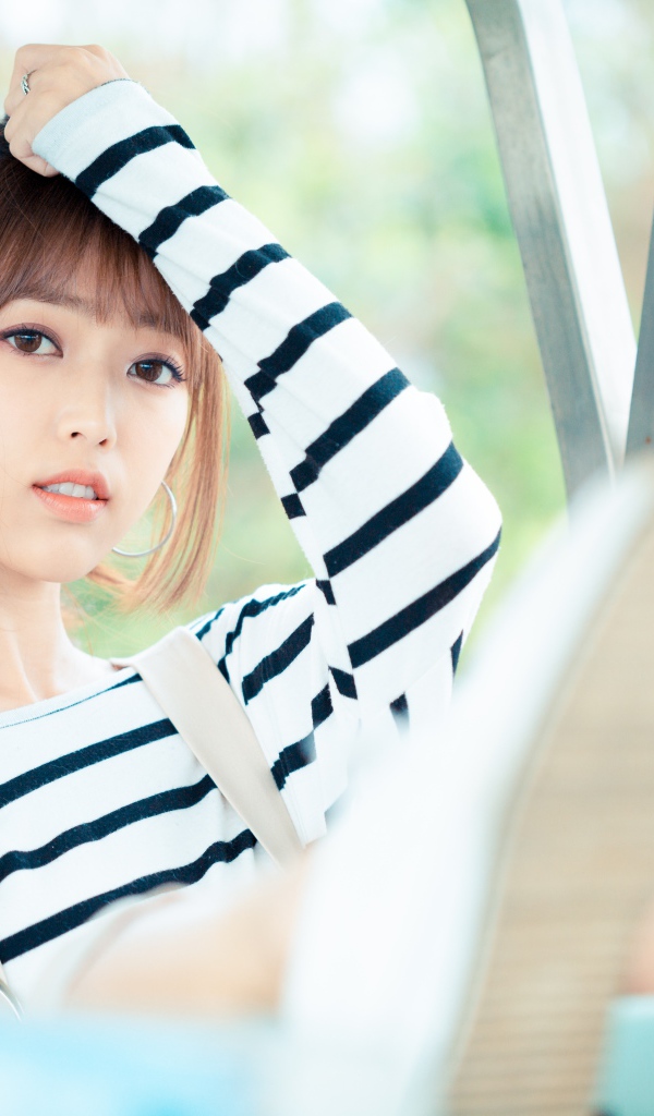 Кареглазая девушка азиатка в полосатом свитере