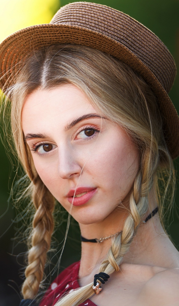 Кареглазая девушка с косами на голове в шляпе