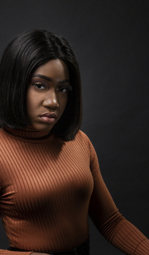 Темнокожая девушка с короткой стрижкой на сером фоне