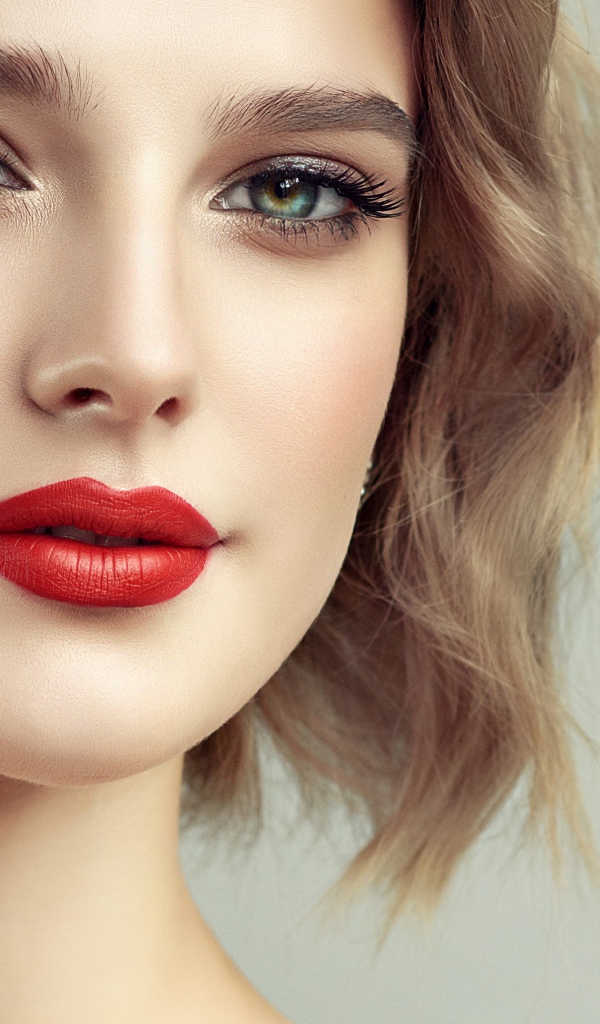 Лицо девушка с красивым макияжем на сером фоне